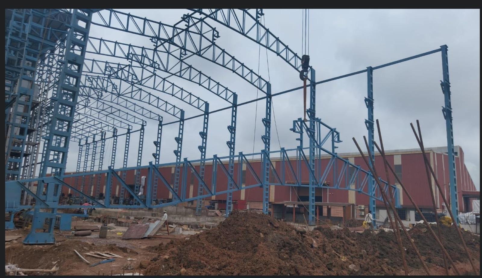 Steel roof trusses and columns being erected for an industrial building